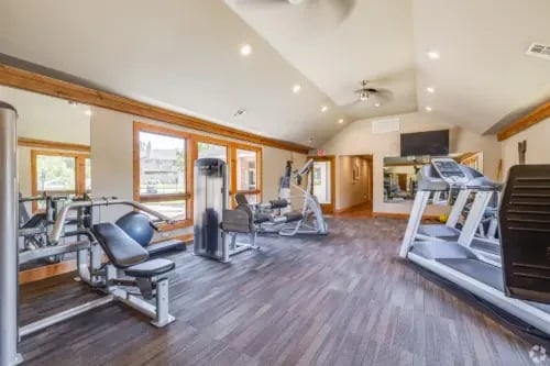 Gym equipment, treadmills and weight machines in a spacious fitness center.