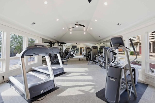 Bright, spacious community gym with treadmills, ellipticals and weight machines.