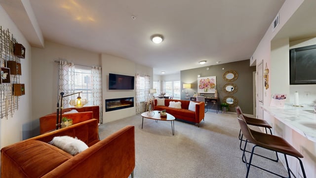 Spacious living room with fireplace, TV, sofa, accent chairs, coffee table, and dining area.