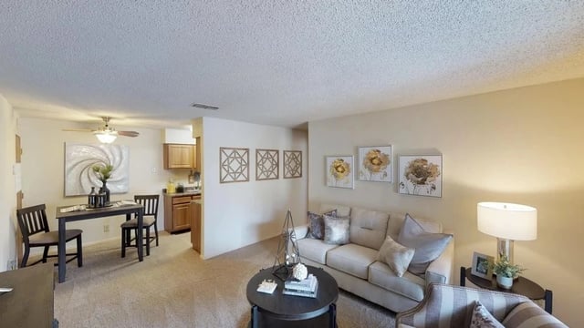 Living room and dining area with sofa, coffee table, and dining set.