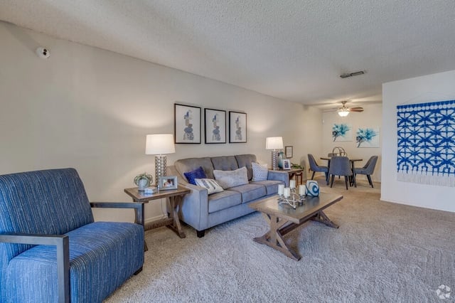 Living room and dining area with a sofa, armchair, coffee table, and dining set.