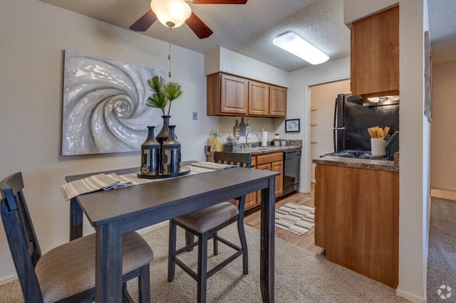 Dining area and kitchen with wooden cabinets and black appliances