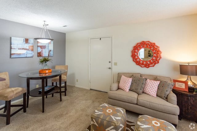 Living room and dining area with a sofa, ottoman, and dining table.