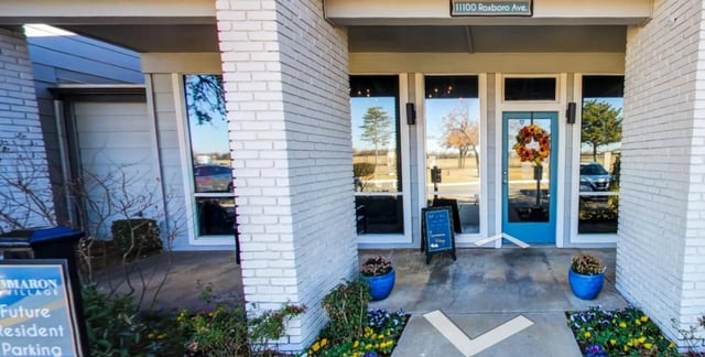 Marron Village building entrance with blue door and wreath.