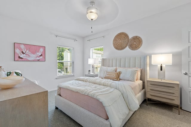Brightly decorated bedroom with bed, nightstand, and wall artwork.