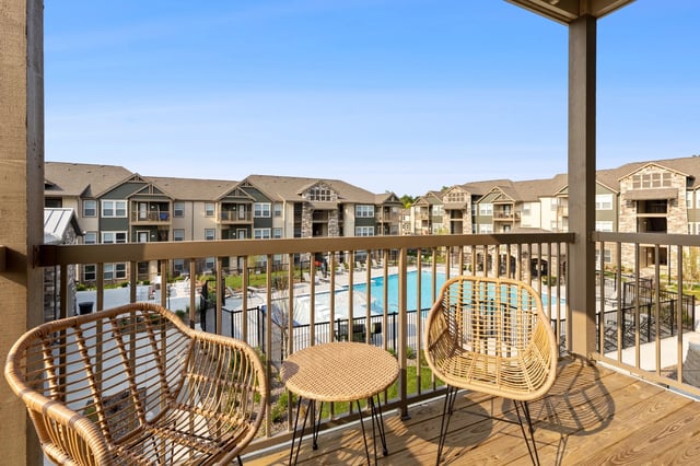 View of a balcony overlooking a pool and apartment buildings