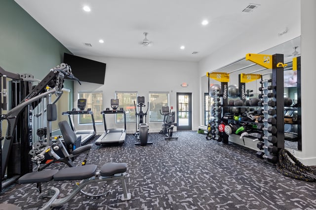 Fitness center with cardio machines, weight machines, free weights, and yoga balls.