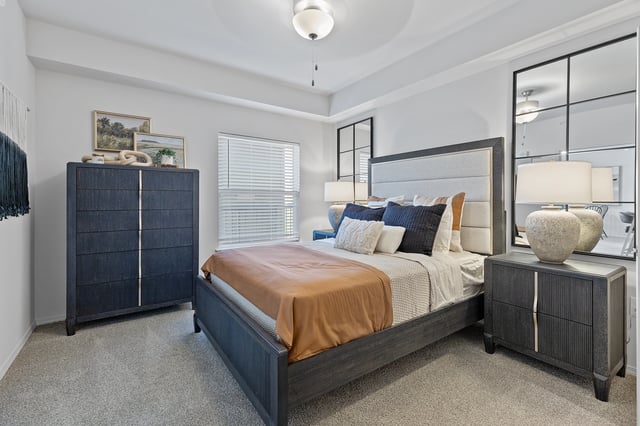 Primary bedroom with a king-sized bed, dark wood furniture, and large mirrors.