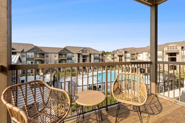 View from balcony overlooking a pool and apartment buildings.