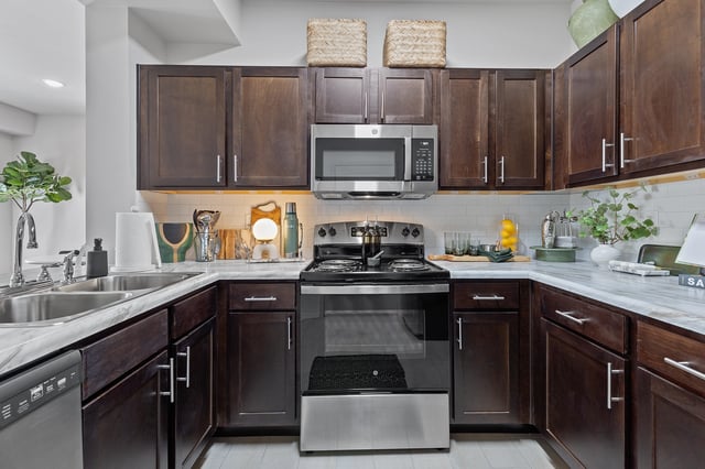 Modern kitchen with dark wood cabinets, stainless steel appliances, and white subway tile backsplash.