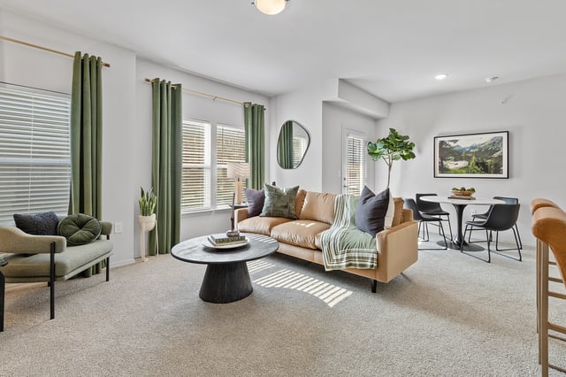 Living room with sofa, armchair, coffee table, and dining area.