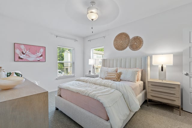 A beautifully staged bedroom with a king-sized bed, nightstands, and a dresser.