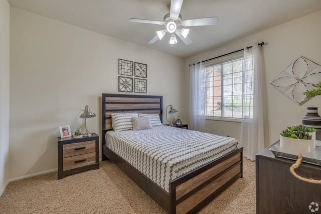 Bedroom with a queen-size bed, nightstand, and window.