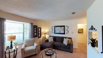 Living room with sectional sofa, armchair, coffee table, and large window.
