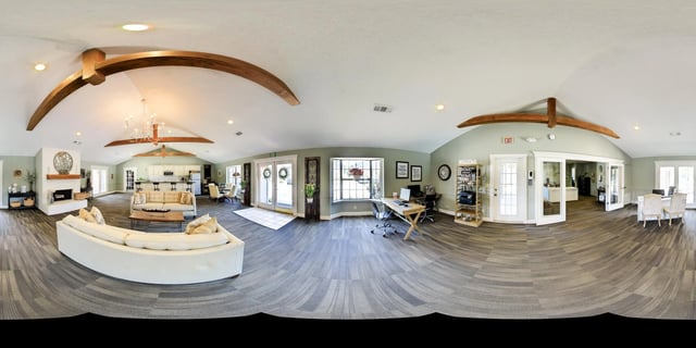 Clubhouse interior with seating areas, fireplace, and kitchenette.