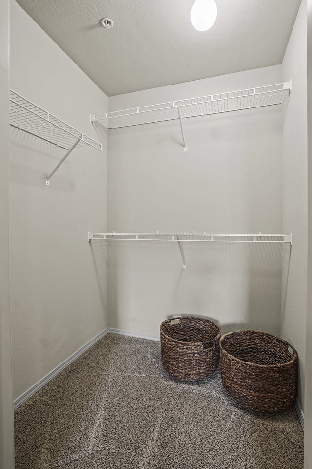 Empty walk-in closet with shelves and two storage baskets