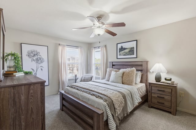 Bedroom with a queen-size bed, dresser, and nightstand.
