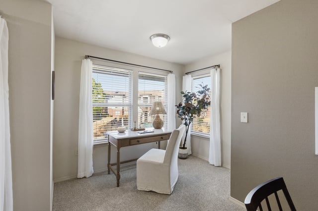Desk and chair near windows in an apartment.