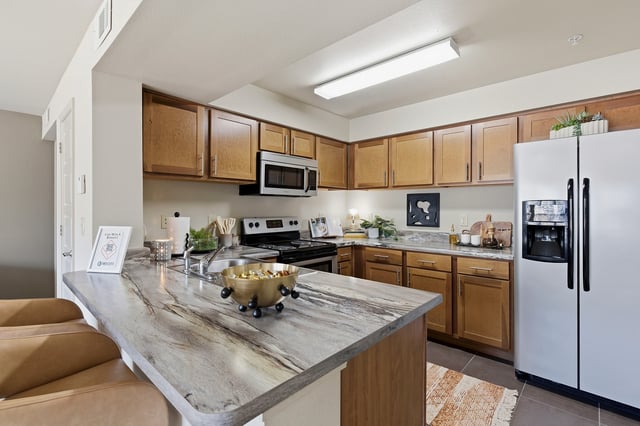 Modern kitchen with granite countertops, stainless steel appliances, and wood cabinetry.