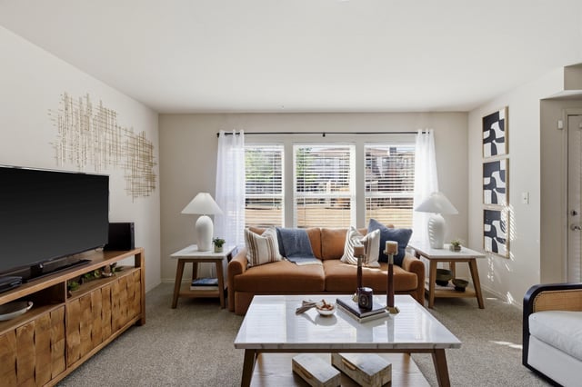 Living room with a brown sofa, marble coffee table, and TV.