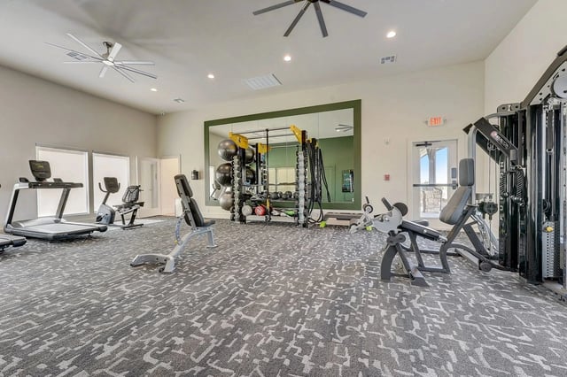 Gym with treadmills, exercise bikes, weight machines, and free weights.