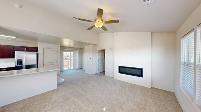 Spacious living room with fireplace and open kitchen area.