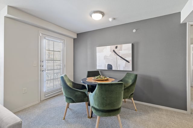 A dining room with a table set for four.