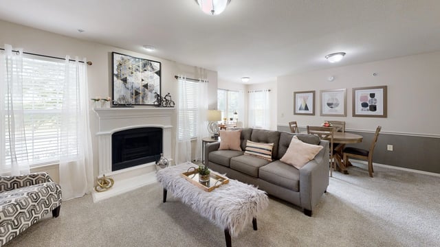Spacious living room with a fireplace, sofa, and dining area.