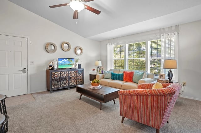 Living room with a sofa, armchair, coffee table, and TV.