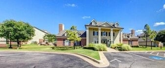 Exterior view of the apartment building entrance and surrounding grounds.