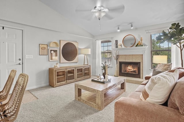 Cozy living room with a fireplace, sofa, coffee table, and TV stand.