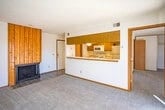 Living room with fireplace and view into kitchen