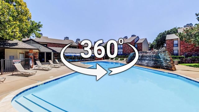360-degree view of an outdoor swimming pool with lounge chairs and apartment buildings in the background.