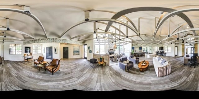 Spacious communal lounge area with seating, a dining table, and a kitchen counter.