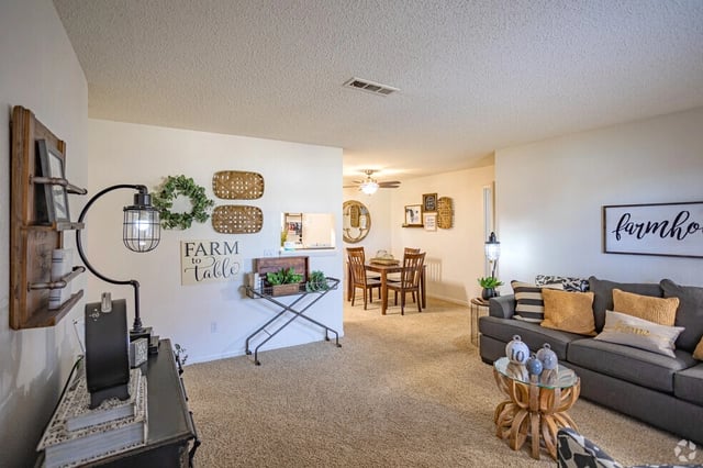 Living room with farmhouse decor, grey couch, and dining area.