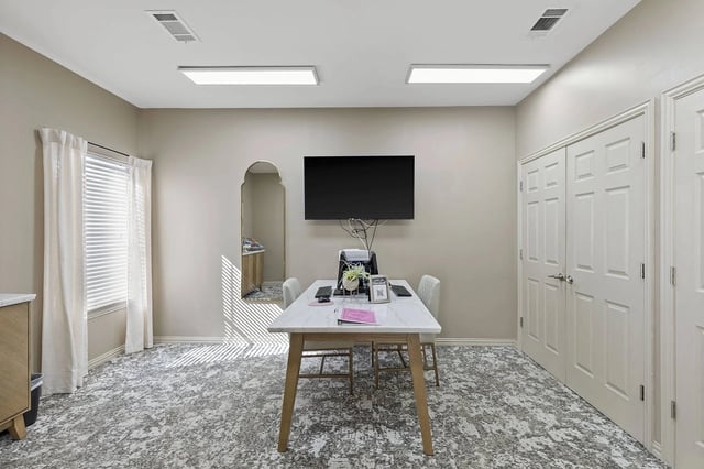 Leasing office/lounge with a table, chairs, and a wall-mounted TV.