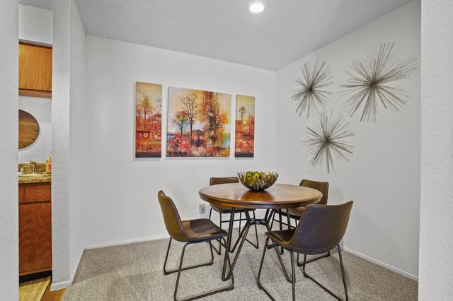 Dining area with a round wooden table and four chairs.