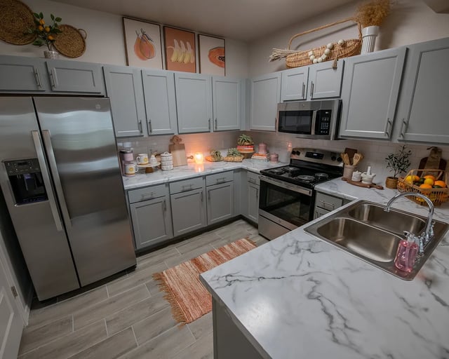 Modern gray kitchen with stainless steel appliances and marble countertops.