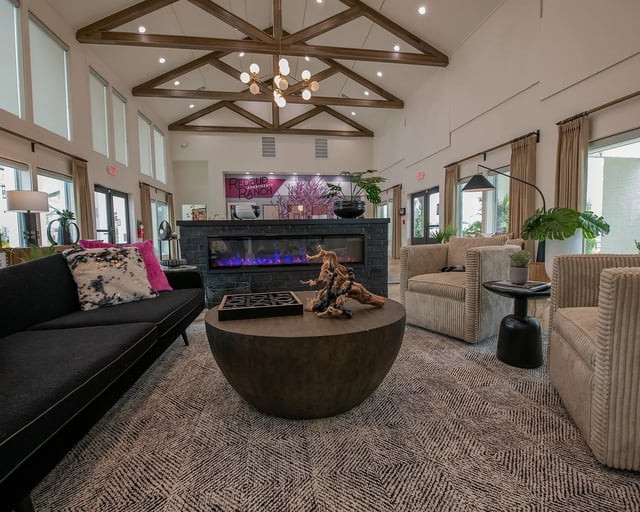 Modern apartment community lounge with fireplace, comfortable seating, and contemporary decor.