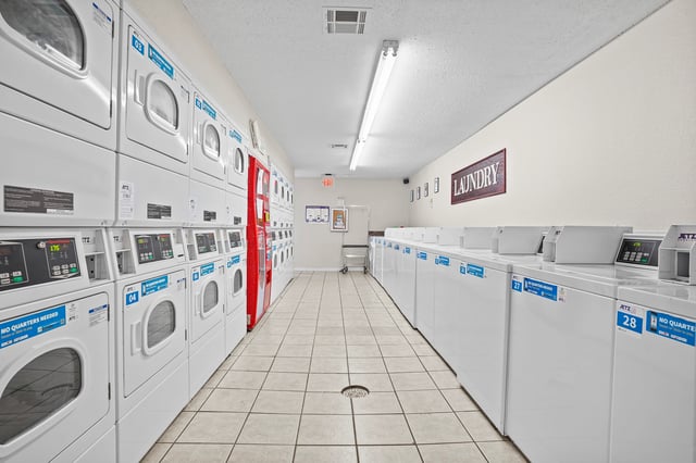 Laundry room with stacked washers and dryers on the left and single washers on the right.