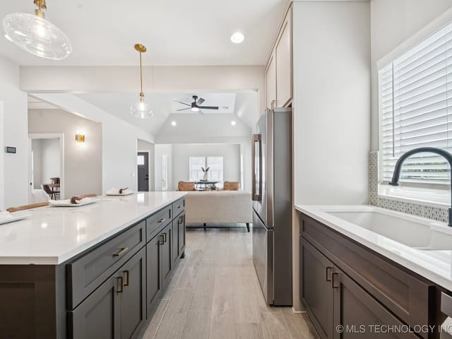 Modern kitchen featuring a large island with dark cabinetry and stainless steel appliances.