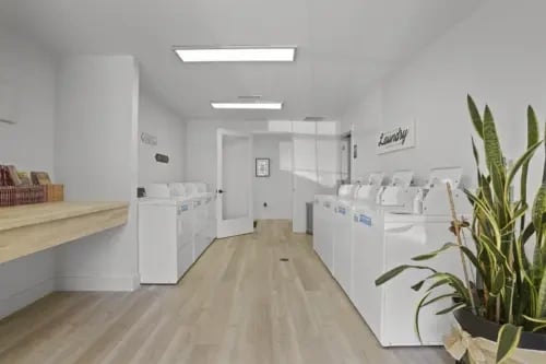 Laundry room with multiple washing machines and dryers