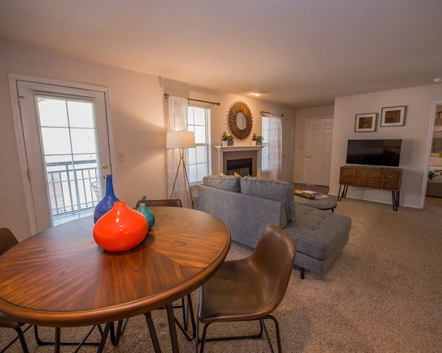 A living room with a grey couch, a wooden table, and a chair.