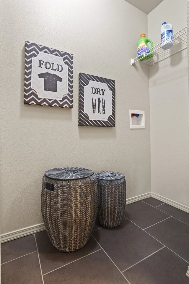 Two wicker baskets are on the floor under a sign that says "Fold T-shirt" and another sign that says "Dry VHB".