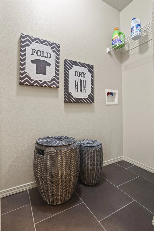 Two wicker baskets are on the floor under a sign that says "Fold T-shirt" and another sign that says "Dry VHB".