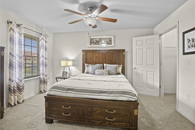 Bedroom with a large wooden bed, nightstand, and window.
