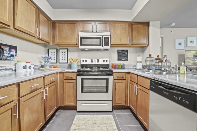 Modern kitchen with wood cabinets, stainless steel appliances, and granite countertops.