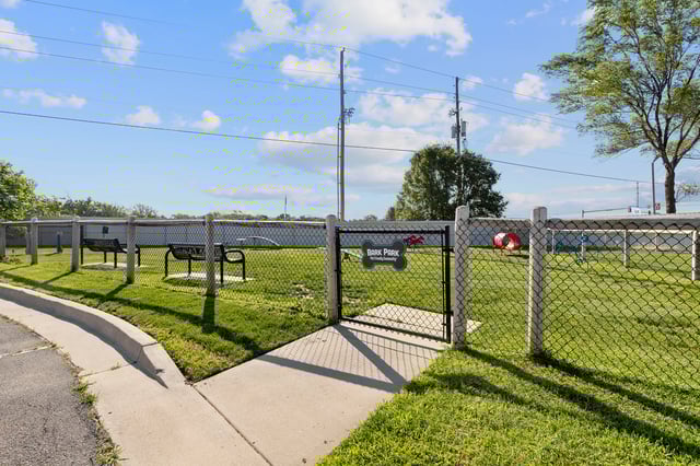 Dog park with benches, agility equipment, and a red tunnel.