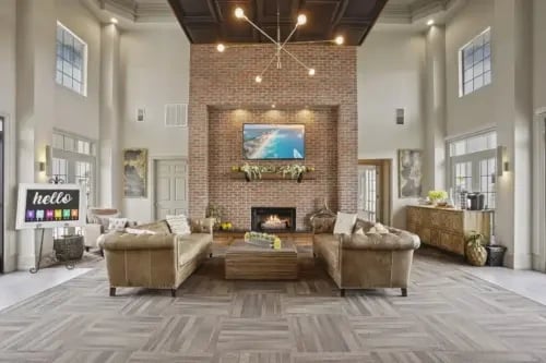 Spacious community lounge with fireplace, seating areas, and coffee station.