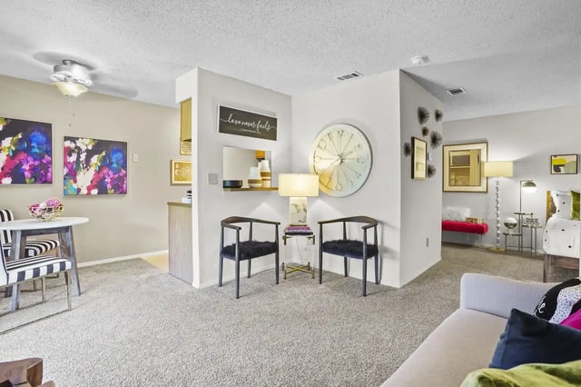 Living area of an apartment featuring a small dining table, two chairs, and decorative elements.